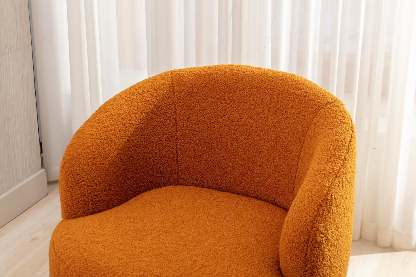Sillón giratorio de tela Teddy con acento tipo barril y aro metálico con recubrimiento en polvo negro, color caramelo