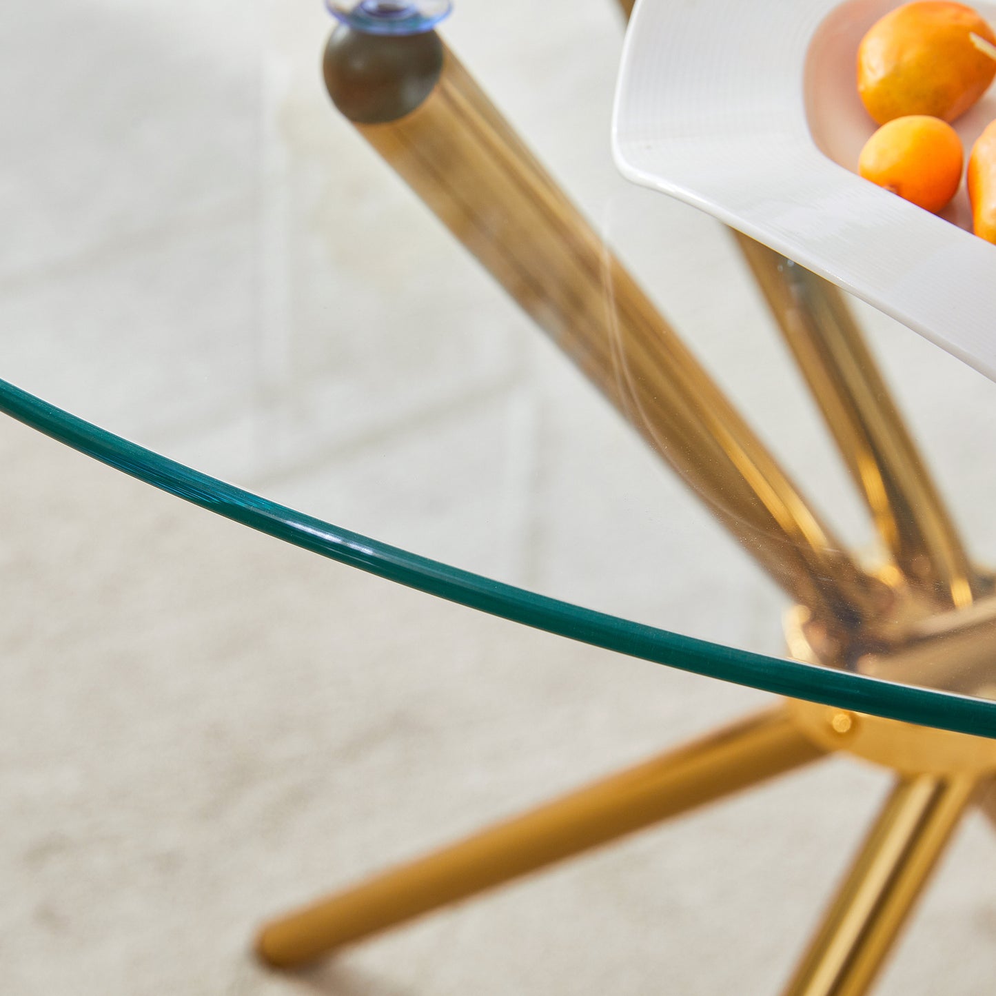 Round clear glass dining table with a unique shape for 4-6 people, with ring-shaped gathered gold metal legs, suitable for desks, kitchens, terraces, dining rooms.